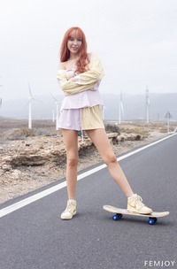 Monica I Posing Topless On A Skateboard Outdoors In Striped Shorts With Wind Turbines Behind